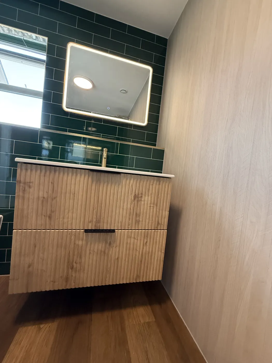 Wall-hung oak vanity with LED mirror and brass tap